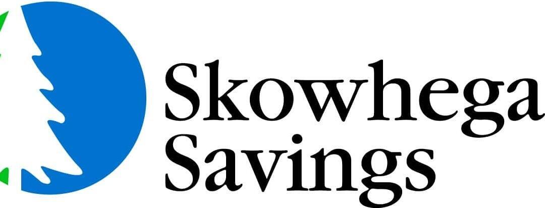 Logo of Skowhegan Savings featuring a stylized white pine tree on a blue and green circular background, accompanied by the text "Skowhegan Savings" in black.